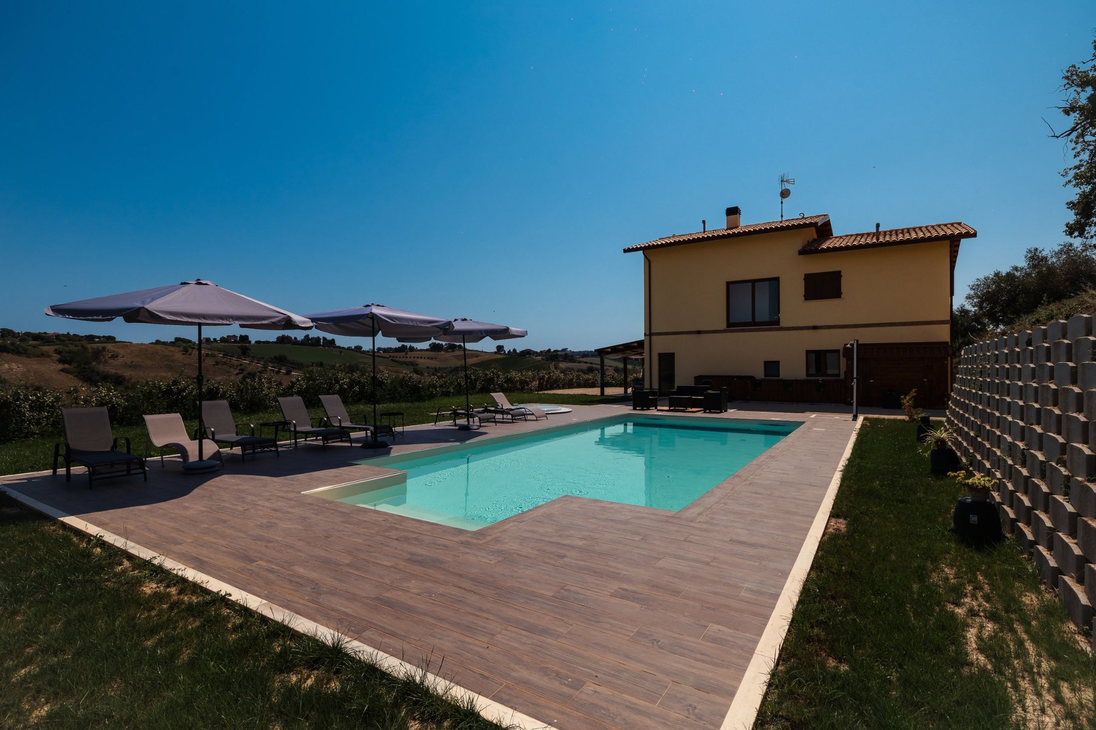 La facciata di Villa Aura con la piscina e gli ombrelloni